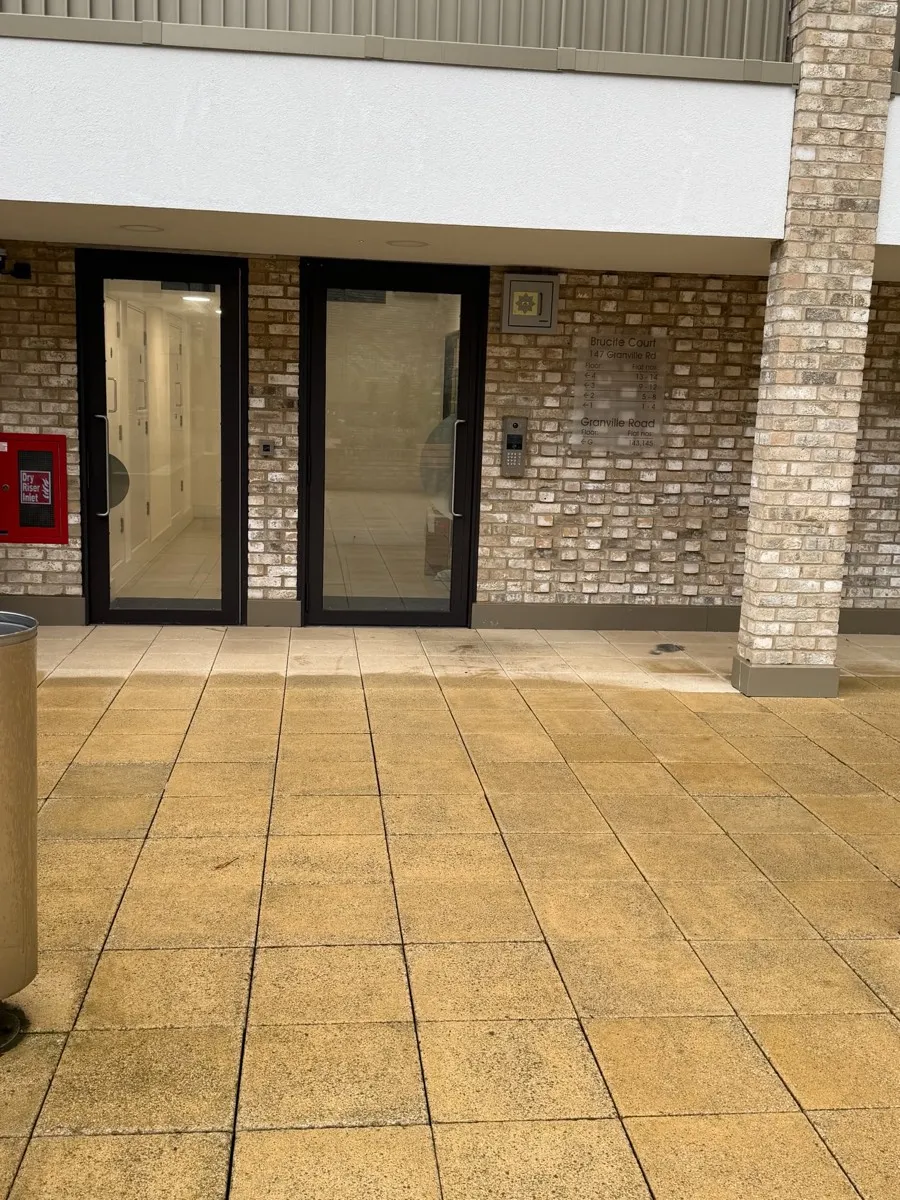 The entrance to Brucite Court: glass doors set into brick under the building, with a red fire box to the left.