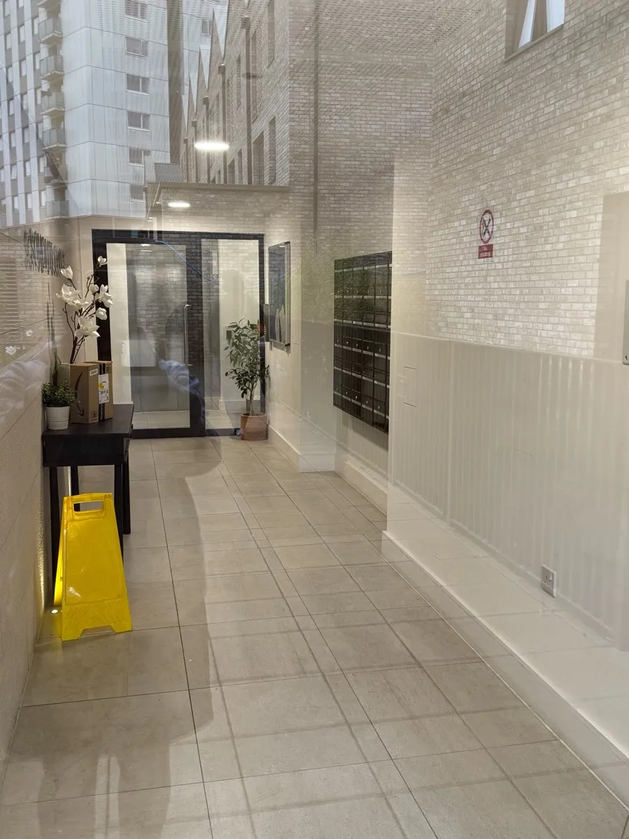 Inside the Sonolite Court lobby: a tiled corridor with wall-mounted post boxes.