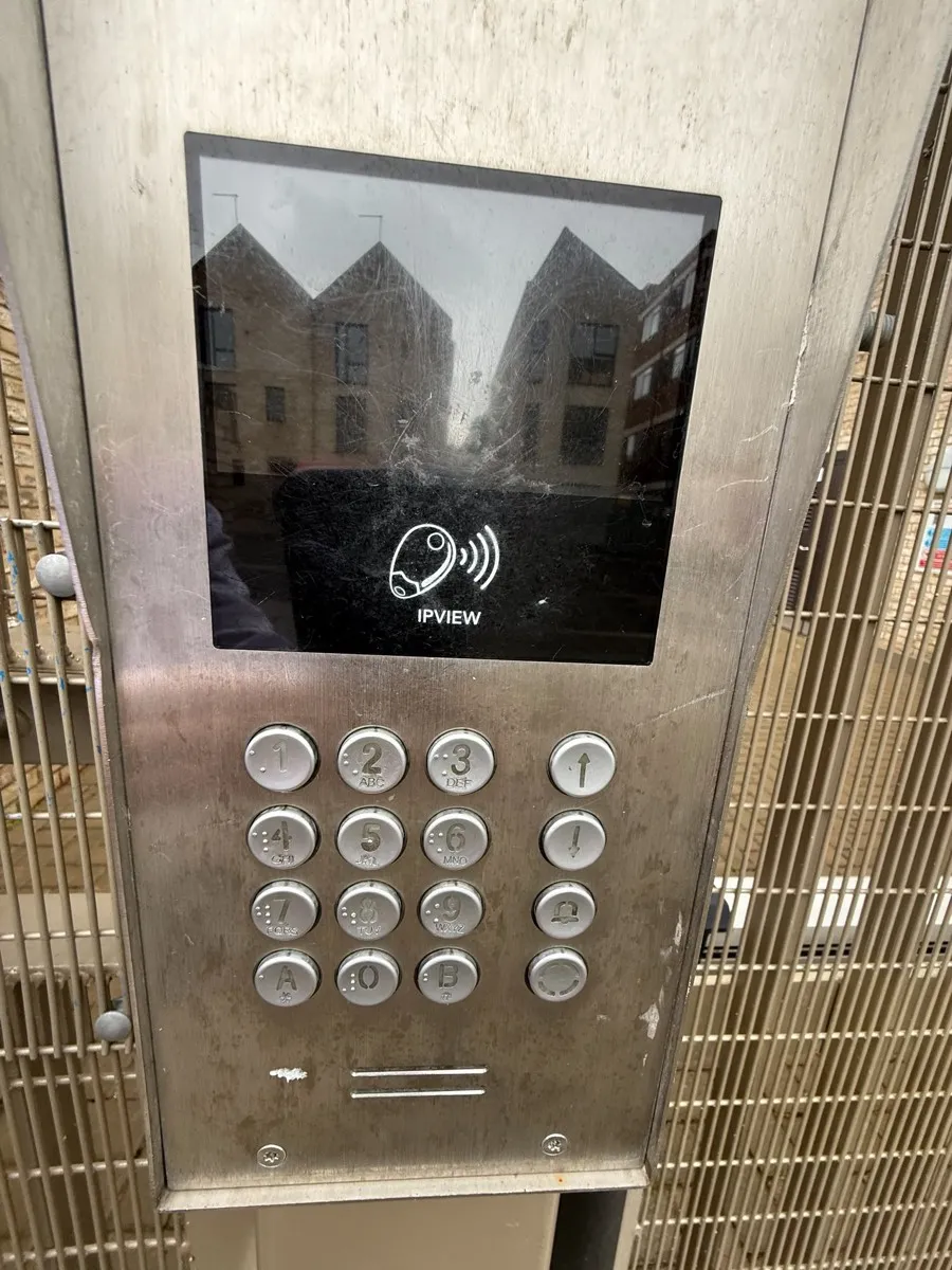 The IPVIEW intercom keypad at the development entrance, with a screen and numbered buttons.